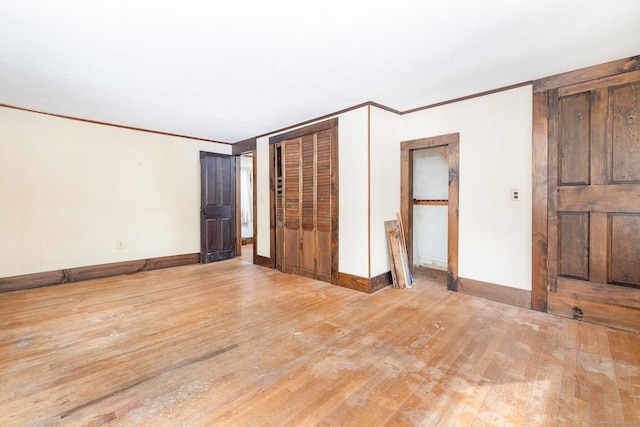 unfurnished bedroom with crown molding, hardwood / wood-style floors, and a closet