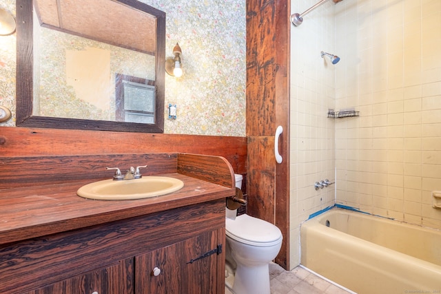 full bathroom with vanity, tiled shower / bath combo, and toilet