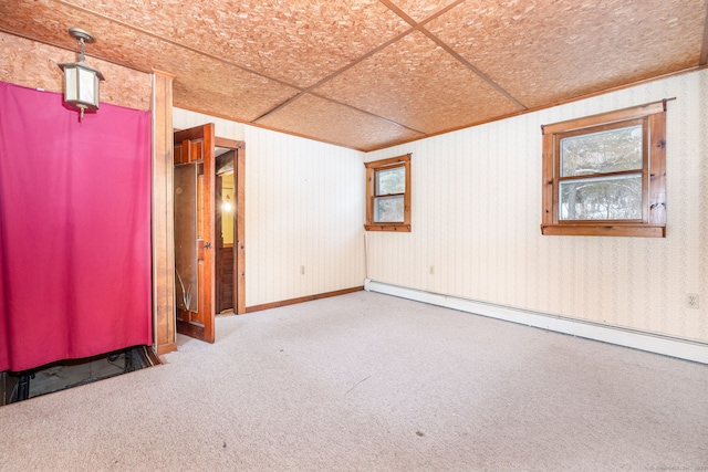 basement with carpet, a healthy amount of sunlight, and baseboard heating