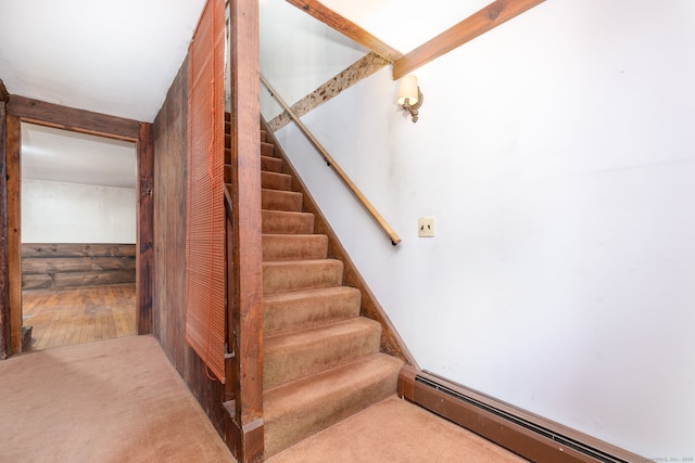 staircase with beam ceiling, carpet, and baseboard heating