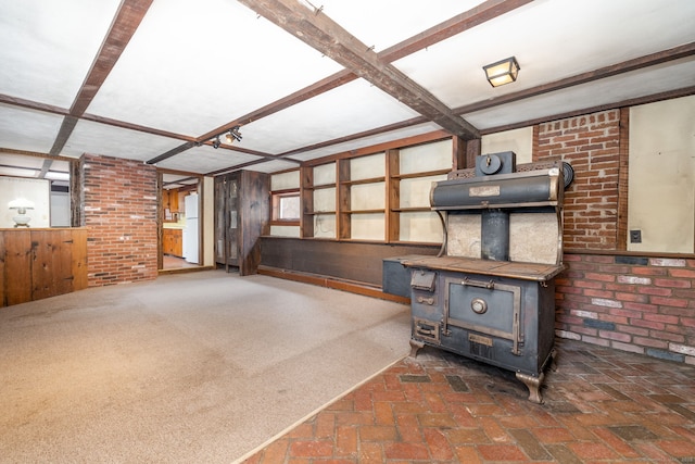 unfurnished living room featuring dark colored carpet, a wood stove, and wooden walls