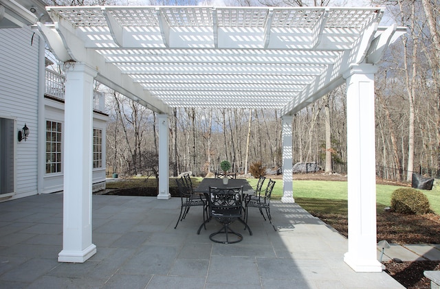 view of patio featuring outdoor dining space, fence, and a pergola