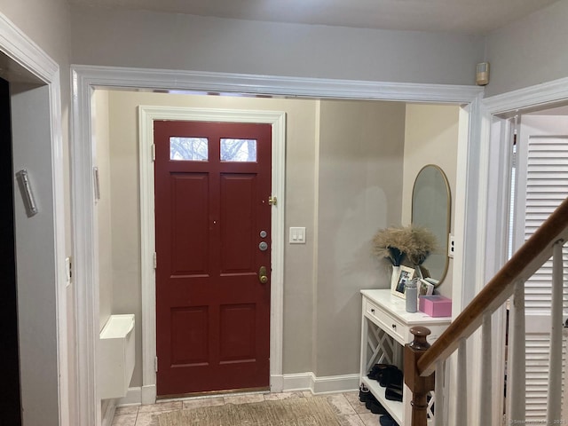 foyer featuring stairway and baseboards