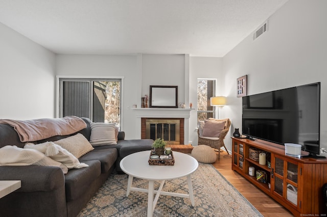 living room with hardwood / wood-style flooring and a brick fireplace