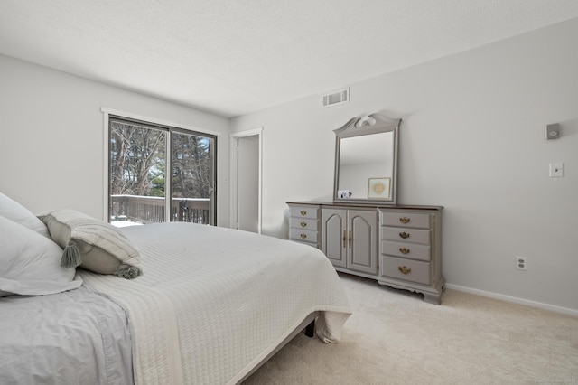 bedroom featuring access to outside, a textured ceiling, and light colored carpet