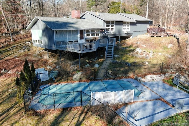 rear view of property with a sunroom and a swimming pool side deck