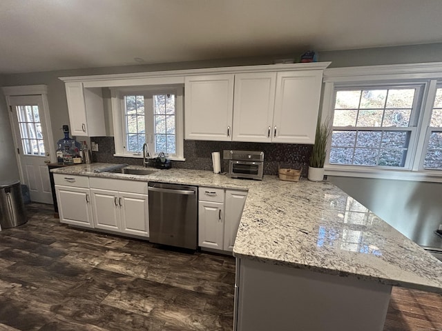 kitchen featuring a sink, plenty of natural light, dishwasher, and white cabinetry