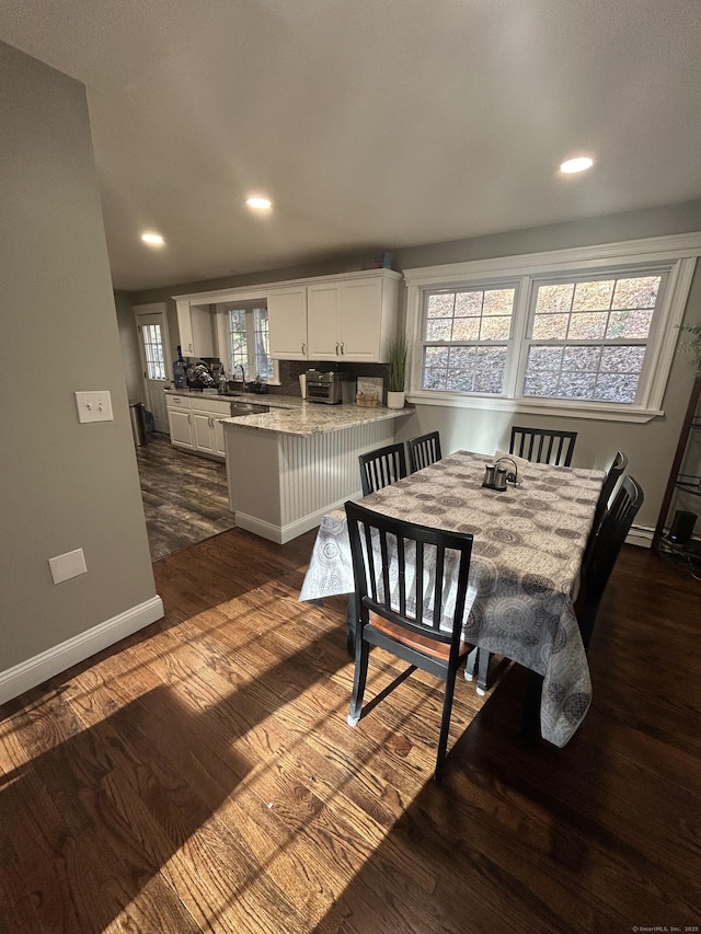 dining room with a wealth of natural light, recessed lighting, dark wood-type flooring, and baseboards