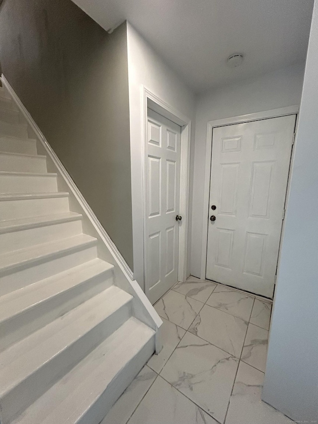 entrance foyer with marble finish floor and stairs