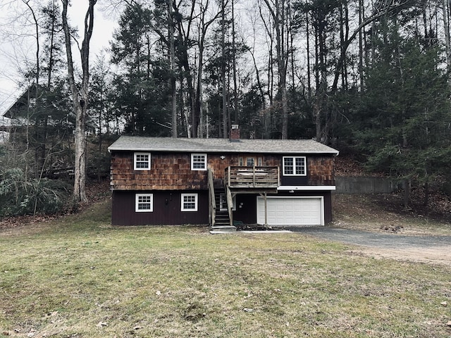 view of front facade with aphalt driveway, stairs, a front yard, a chimney, and an attached garage