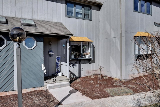 doorway to property featuring a shingled roof