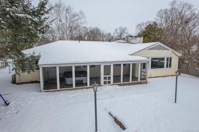 snow covered property with a sunroom