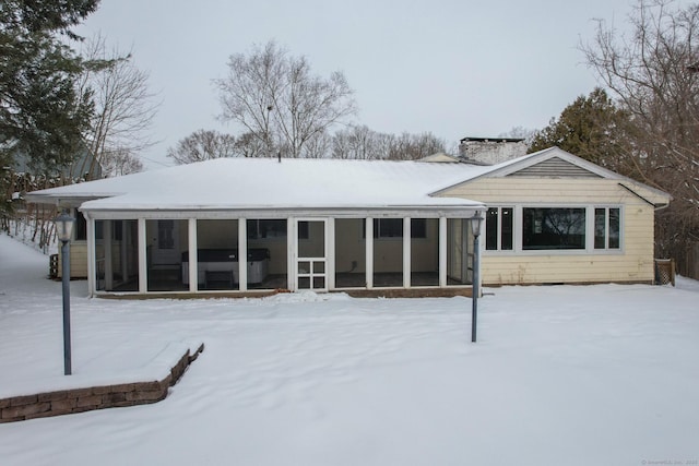 snow covered house with a sunroom