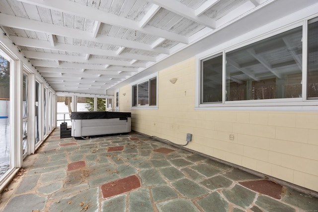 unfurnished sunroom featuring beamed ceiling