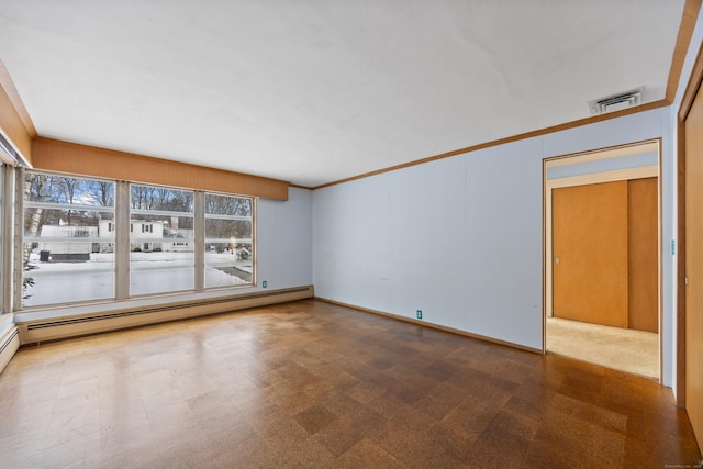 spare room with ornamental molding and a baseboard heating unit