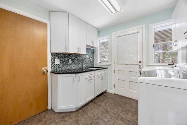 kitchen featuring sink, a wealth of natural light, white cabinets, and decorative backsplash