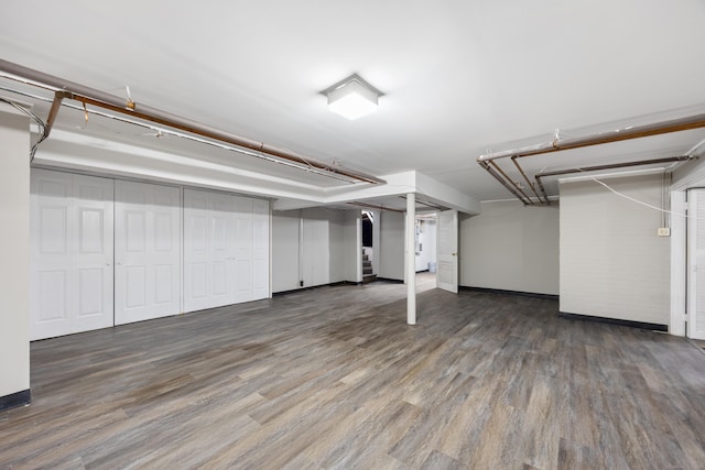 basement with dark hardwood / wood-style floors