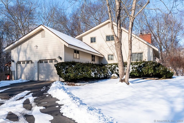 view of snow covered exterior featuring a garage