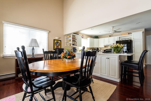 dining space featuring dark hardwood / wood-style flooring, ceiling fan, and a high ceiling