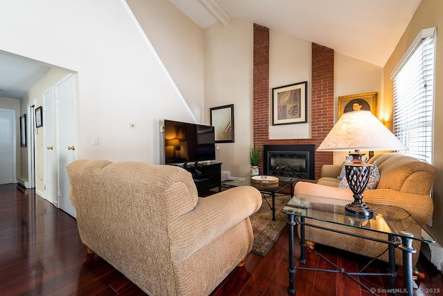 living room with beamed ceiling, dark hardwood / wood-style flooring, high vaulted ceiling, and a brick fireplace