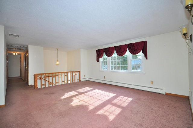 carpeted spare room featuring a textured ceiling and a baseboard heating unit