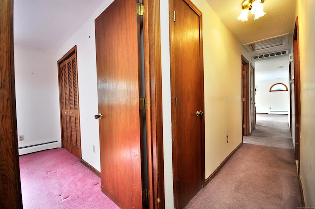 hallway featuring a baseboard heating unit and carpet floors