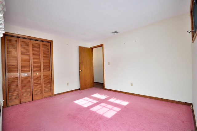 unfurnished bedroom with light colored carpet and a closet