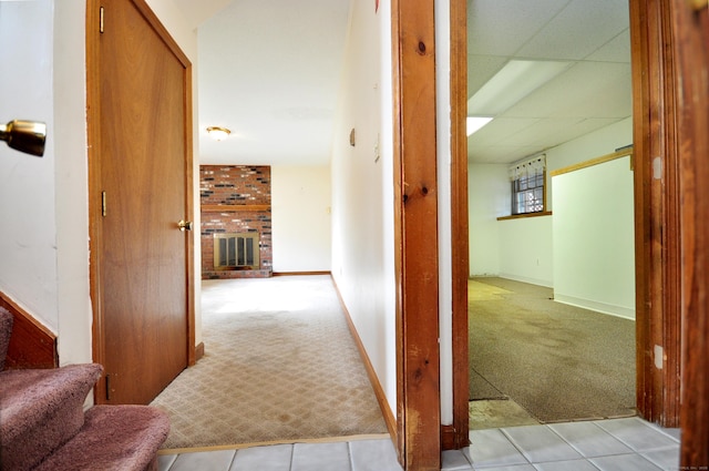 hallway featuring a drop ceiling and light colored carpet