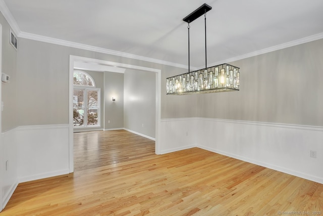 unfurnished dining area featuring visible vents, wood finished floors, and ornamental molding