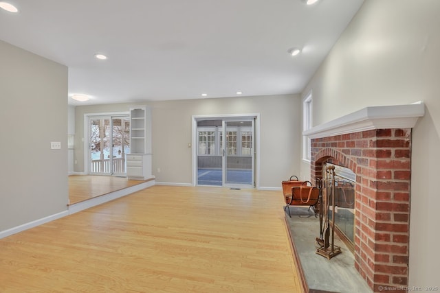 living room with hardwood / wood-style floors and a brick fireplace