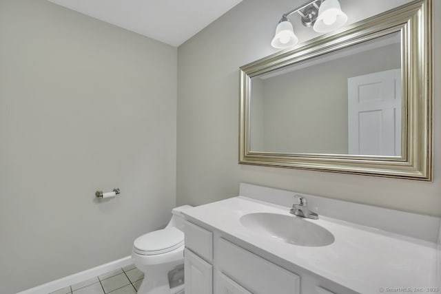 bathroom featuring baseboards, vanity, tile patterned flooring, and toilet