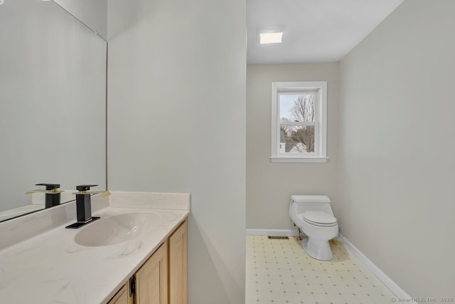 bathroom featuring toilet, tile patterned floors, vanity, baseboards, and visible vents
