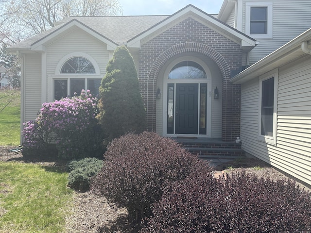 doorway to property with brick siding