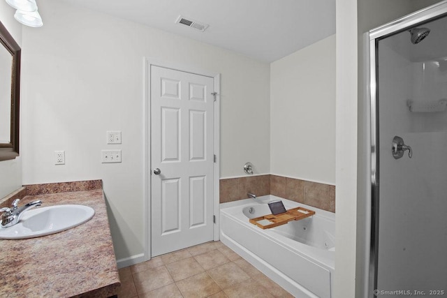 bathroom featuring vanity, a bath, and tile patterned floors