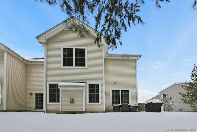 view of snow covered back of property