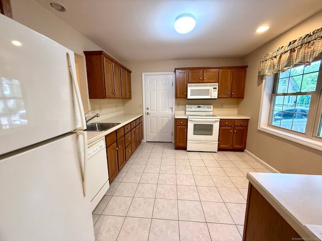 4 Amberly Ln Unit 4, East Lyme, CT 06357 - kitchen featuring white appliances, a sink, light countertops, light tile patterned floors, and brown cabinets