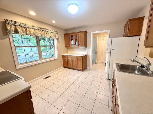 4 Amberly Ln Unit 4, East Lyme, CT 06357 - kitchen featuring a sink, brown cabinetry, light tile patterned floors, baseboards, and light countertops