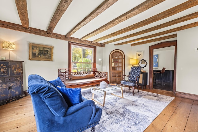 living room featuring beamed ceiling and hardwood / wood-style floors