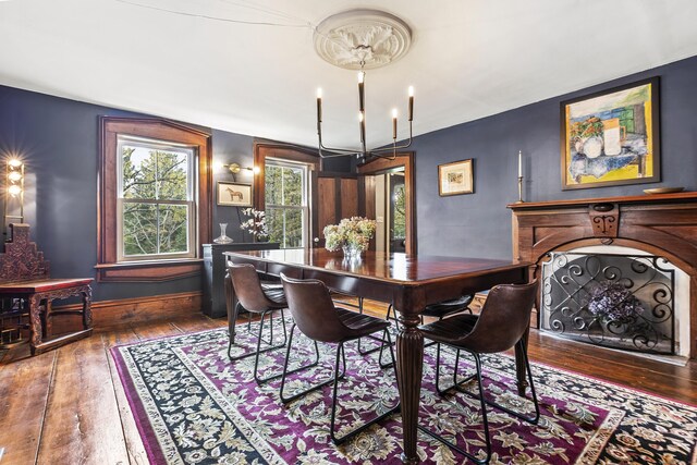 dining area with wood-type flooring and a chandelier