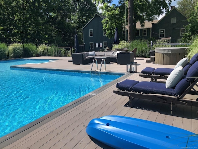 view of swimming pool featuring a wooden deck, an outdoor hangout area, and a hot tub