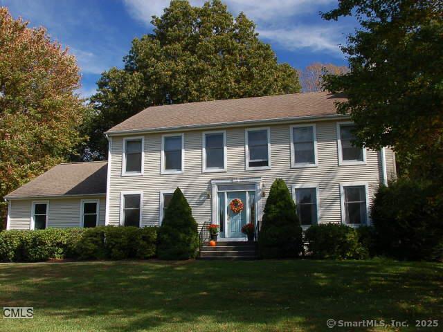 colonial inspired home with a front lawn