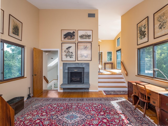 48 Andrews Rd, Guilford, CT 06437 - living room featuring wood finished floors, stairs, a high ceiling, and a tile fireplace