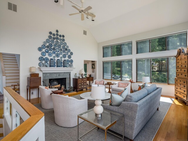 48 Andrews Rd, Guilford, CT 06437 - living area with hardwood / wood-style floors, ceiling fan, a premium fireplace, high vaulted ceiling, and stairway