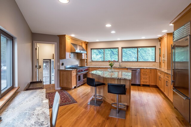 48 Andrews Rd, Guilford, CT 06437 - kitchen featuring premium appliances, wall chimney exhaust hood, tasteful backsplash, light stone countertops, and recessed lighting