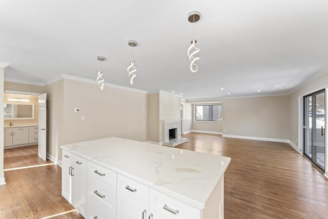 kitchen with wood finished floors, a center island, and ornamental molding