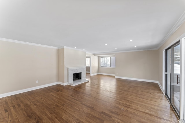 unfurnished living room featuring recessed lighting, wood finished floors, baseboards, and ornamental molding