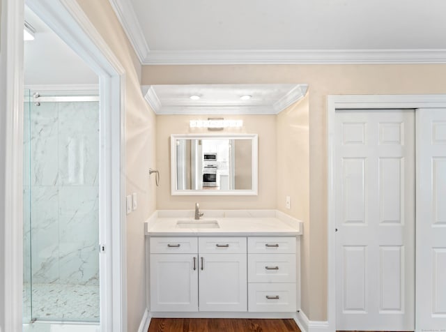 bathroom featuring baseboards, ornamental molding, vanity, and a marble finish shower