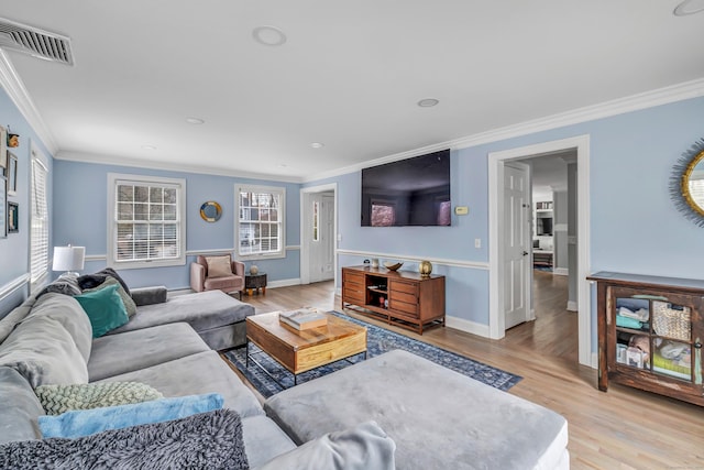 living room with ornamental molding and light hardwood / wood-style floors