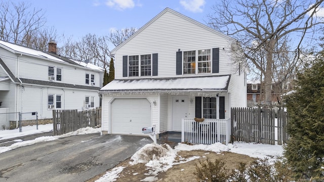 view of front of house featuring aphalt driveway, a porch, an attached garage, and fence