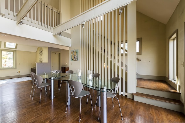 dining room with stairs, high vaulted ceiling, baseboards, and wood-type flooring